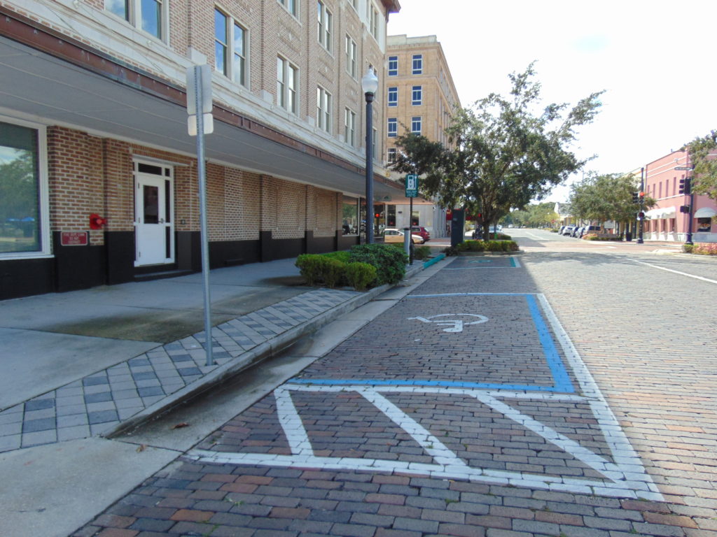 Non-Accessible on street parallel  parking space.  The access aisle leads to a raised curb.. Downtown urban renewal.