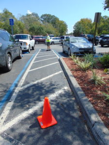 ADA Parking Survey in Florida. Inspecting the cross slopes of a shared accessible aisle of an accessible parking space. Disability Smart Solutions.