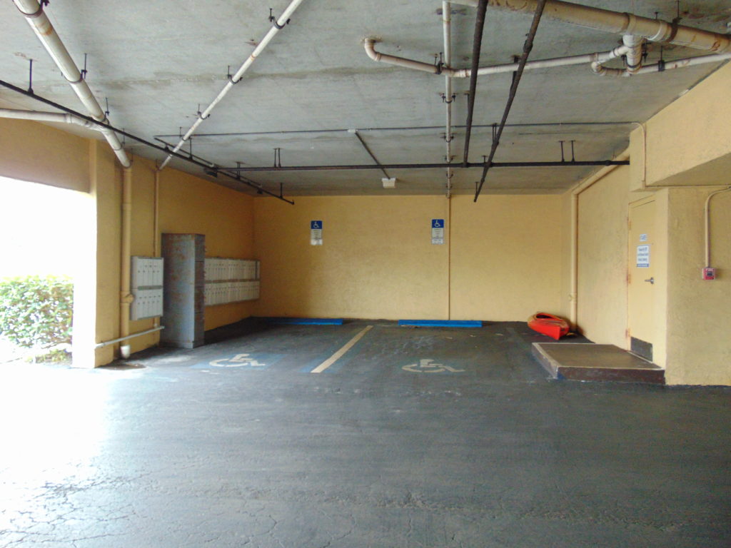 Florida Accessible Parking Fail. Since all Accessible Parking in Florida must be Van Accessible, many parking garages do not provide the clear head room. In this photo there are no accessible aisle, no accessible path and other community mailboxes in the accessible parking space. Disability Smart Solutions.